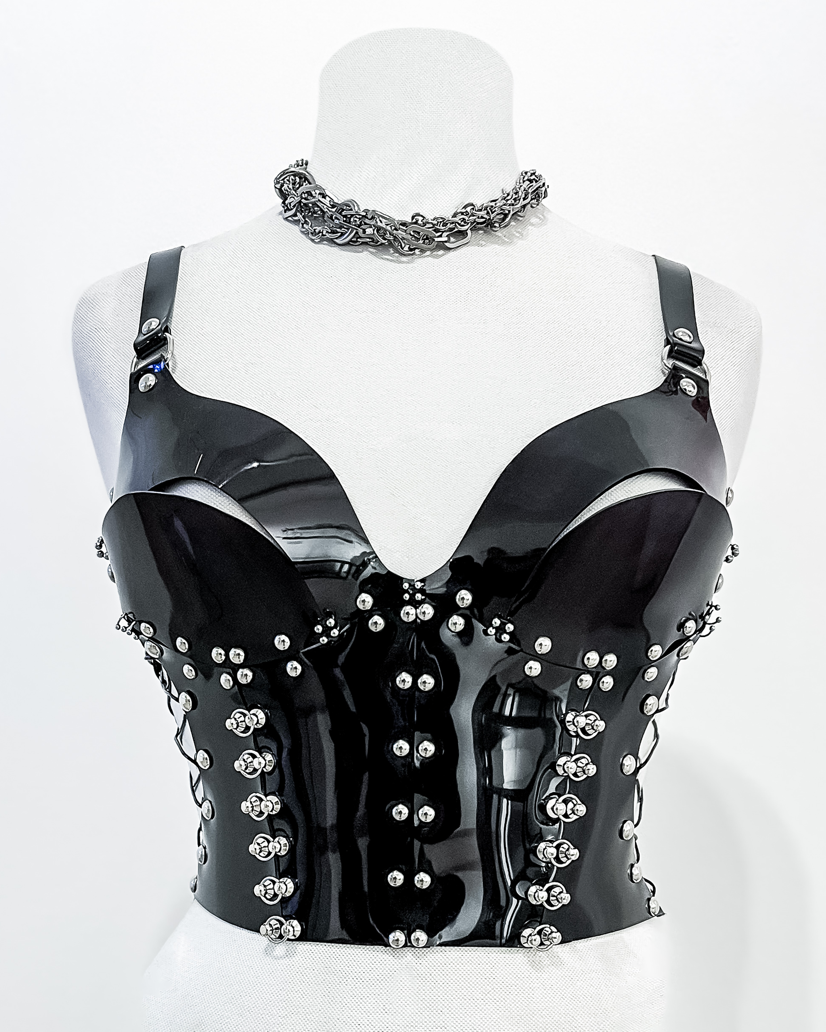 Bustier de PVC negro con diseño remachado futurista y fetichista.