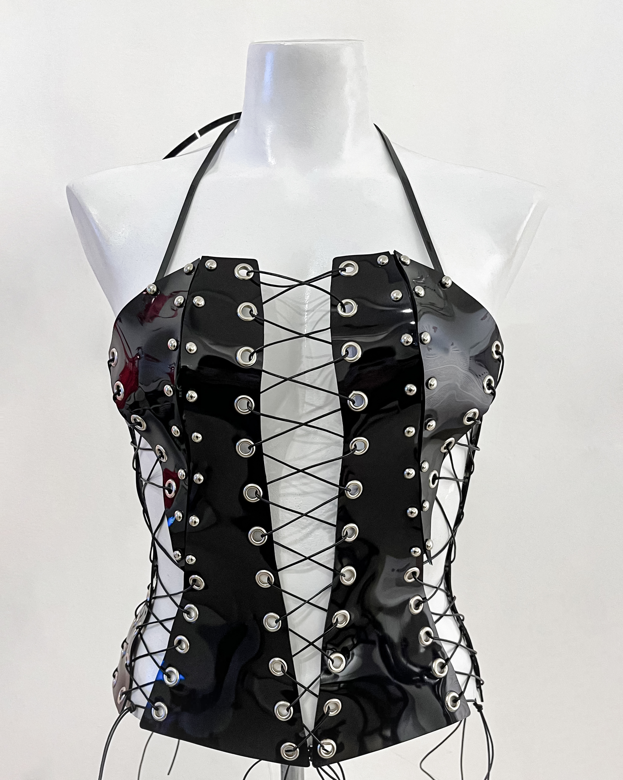 Bustier de PVC negro con remaches y tiras.